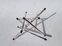 Tensegrity sculpture with six struts of increasing lengths 1 to 2 — polished aluminum, PETG, and stainless steel